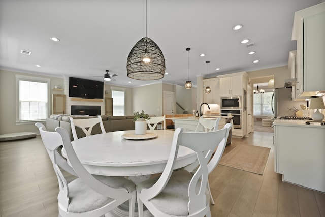3705 Sandy Gate Ln, Mount Pleasant, SC 29466 - dining area with a large fireplace, a ceiling fan, healthy amount of natural light, crown molding, and recessed lighting