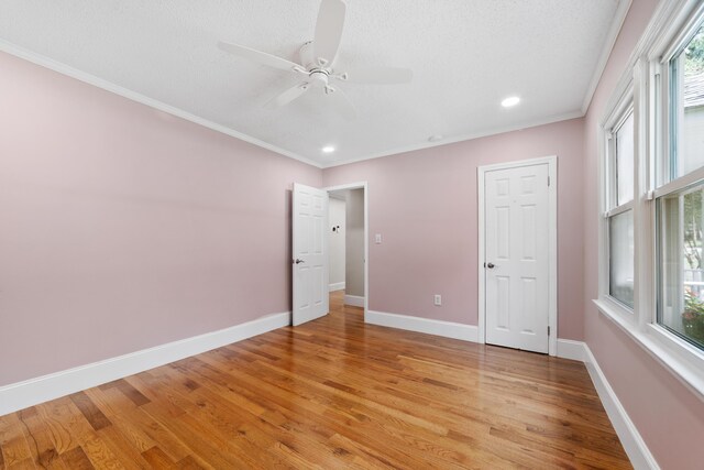 unfurnished bedroom with ceiling fan, light hardwood / wood-style floors, and crown molding