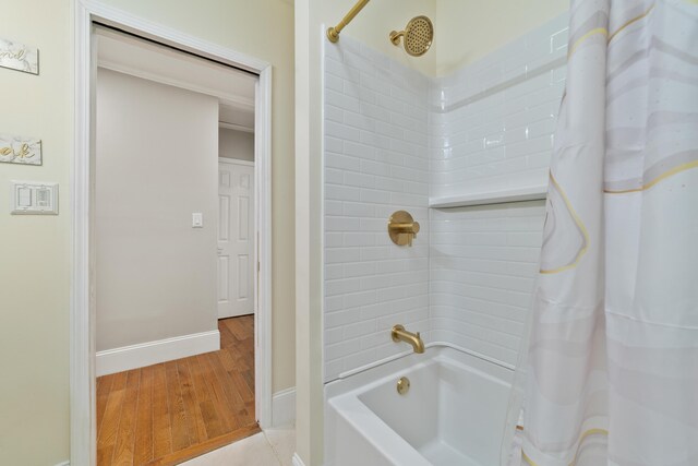 bathroom with hardwood / wood-style flooring and shower / tub combo