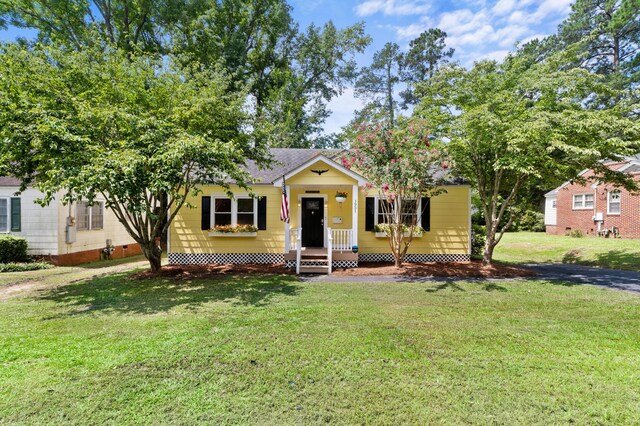 view of front of house with a porch and a front yard