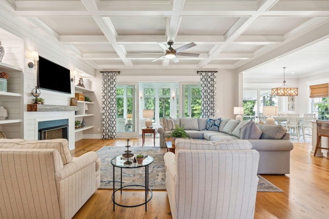 living room with beamed ceiling, ceiling fan with notable chandelier, and a healthy amount of sunlight