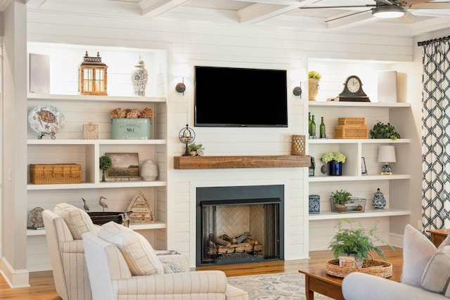 living room featuring beam ceiling, light hardwood / wood-style floors, ceiling fan, and coffered ceiling