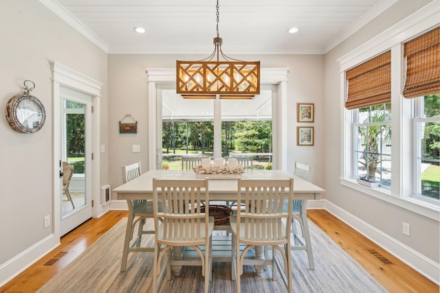 dining space with light hardwood / wood-style floors and ornamental molding