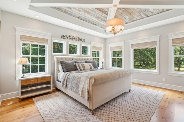 bedroom with light wood-type flooring and an inviting chandelier