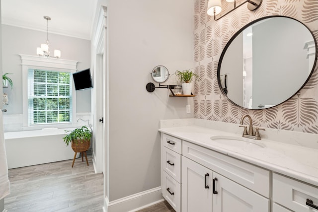 bathroom with a bathing tub, vanity, wood-type flooring, and ornamental molding