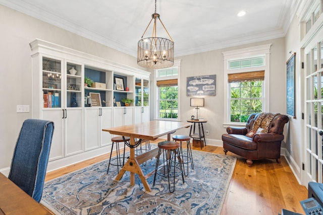 dining area featuring an inviting chandelier, crown molding, and light hardwood / wood-style flooring