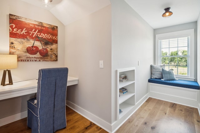 interior space with hardwood / wood-style flooring, built in shelves, and lofted ceiling