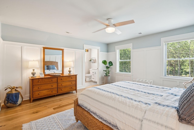 bedroom with ceiling fan, light hardwood / wood-style flooring, and ensuite bath