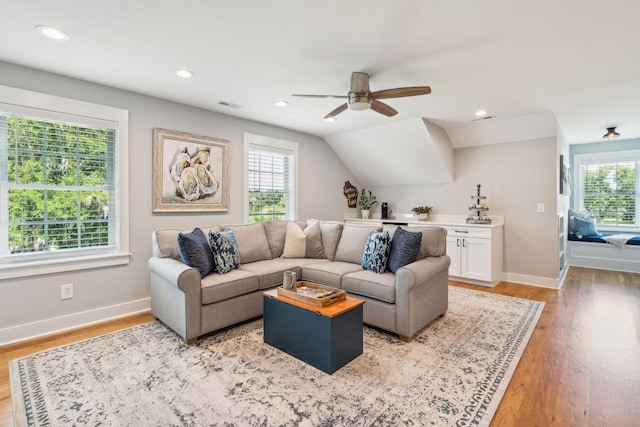 living room featuring ceiling fan, light hardwood / wood-style floors, and lofted ceiling