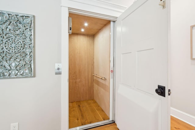 interior details with elevator and hardwood / wood-style floors