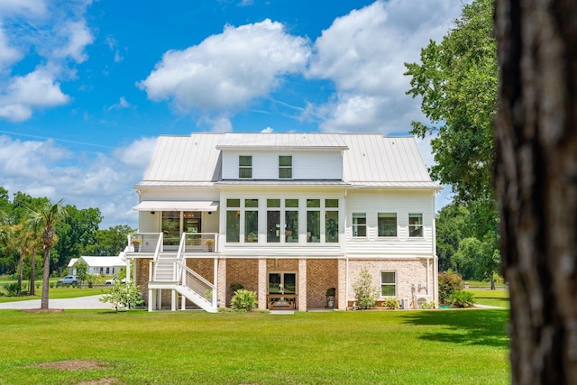 rear view of house featuring a lawn and a sunroom