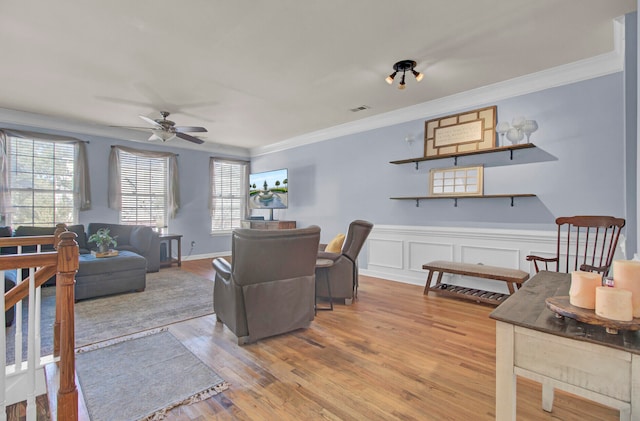 living room featuring ceiling fan, light hardwood / wood-style floors, and ornamental molding