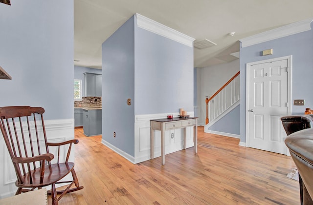 sitting room featuring light hardwood / wood-style flooring and ornamental molding