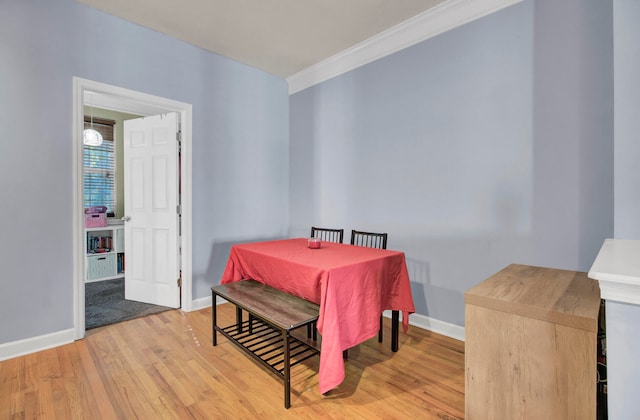 dining area with light hardwood / wood-style floors and crown molding