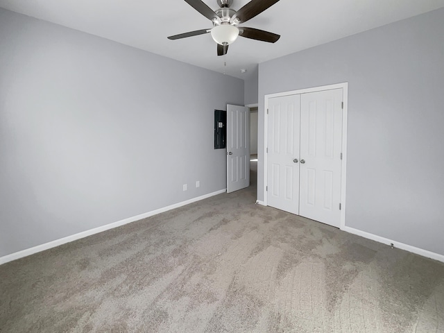 unfurnished bedroom with light carpet, electric panel, ceiling fan, and a closet