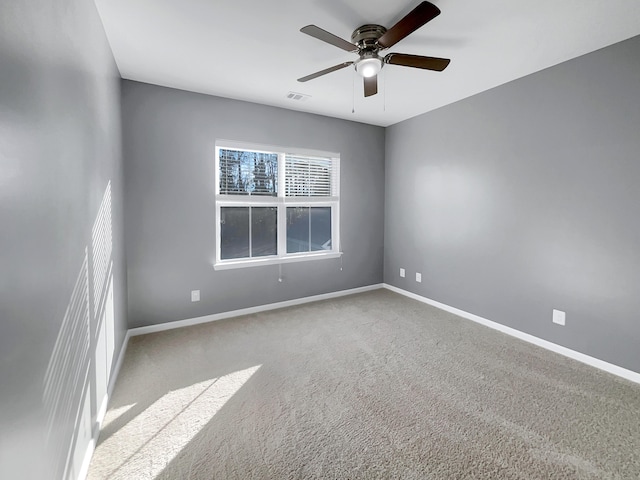 carpeted spare room with ceiling fan