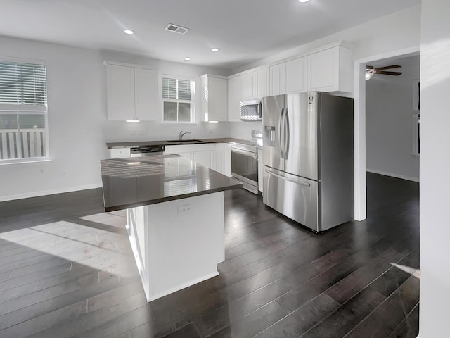 kitchen featuring white cabinetry, appliances with stainless steel finishes, a center island, and sink