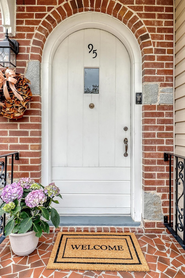 entrance to property featuring brick siding