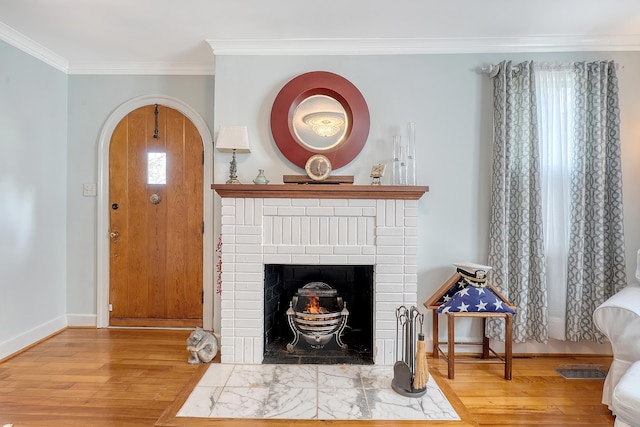 living room featuring ornamental molding, arched walkways, baseboards, and wood finished floors