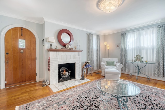 living area featuring arched walkways, ornamental molding, wood finished floors, and baseboards