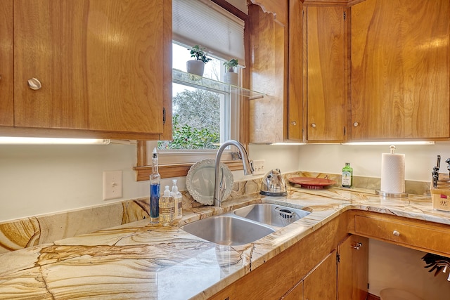 kitchen featuring light countertops, brown cabinetry, and a sink