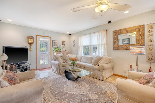 living room featuring recessed lighting, plenty of natural light, and baseboards