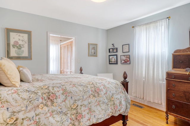 bedroom featuring visible vents and wood finished floors