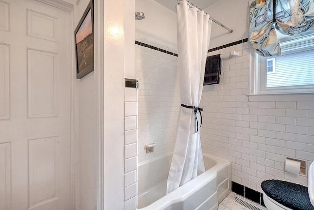 full bathroom featuring tile patterned flooring, shower / tub combo with curtain, tile walls, and toilet