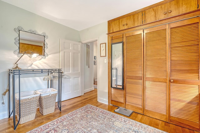 bedroom featuring baseboards, a closet, and light wood-style floors