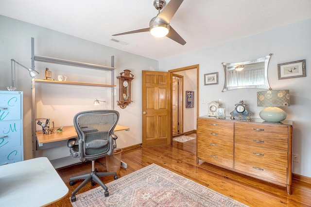 office space with baseboards, visible vents, ceiling fan, and wood finished floors