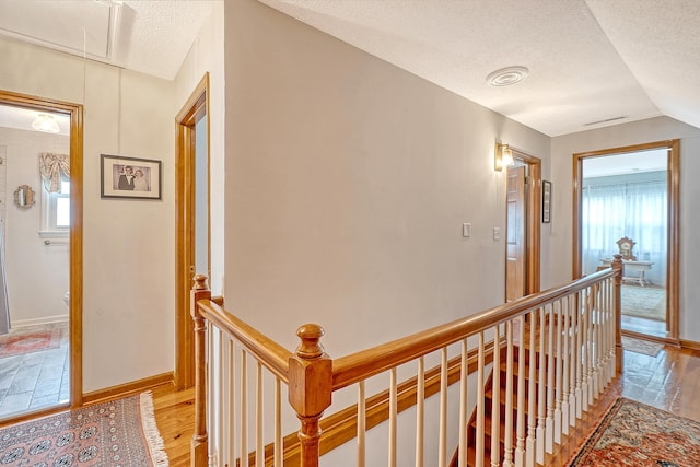 corridor with plenty of natural light, attic access, light wood finished floors, and an upstairs landing