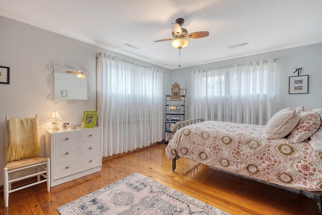 bedroom featuring a textured ceiling, wood finished floors, and visible vents