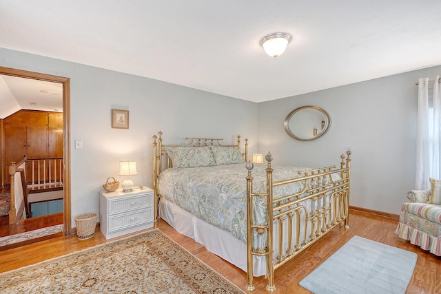 bedroom with baseboards and wood finished floors