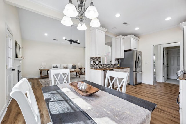 dining space featuring crown molding, wood finished floors, baseboards, visible vents, and recessed lighting