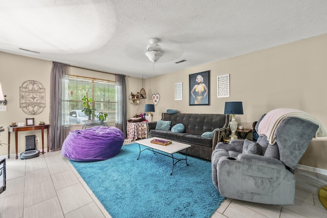 living room featuring ceiling fan, a textured ceiling, and visible vents