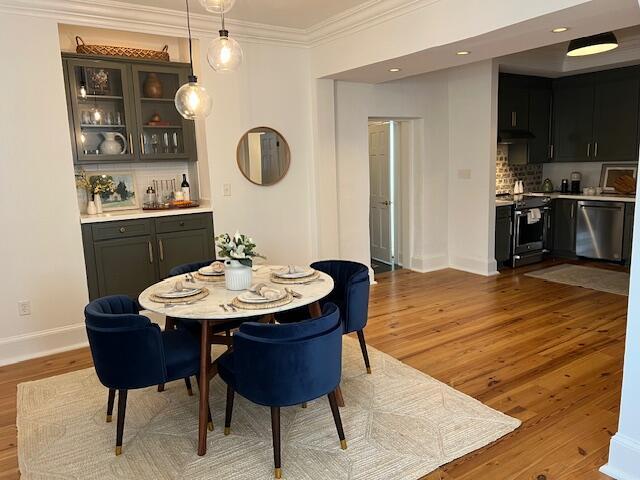 84 Bull St Unit F, Charleston, SC 29401 - dining area with crown molding, light wood-type flooring, baseboards, bar, and recessed lighting
