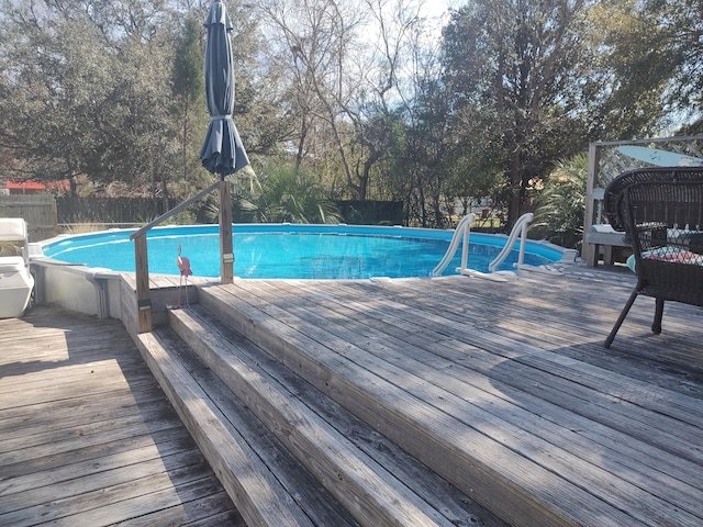 view of pool with a fenced in pool, a fenced backyard, and a wooden deck