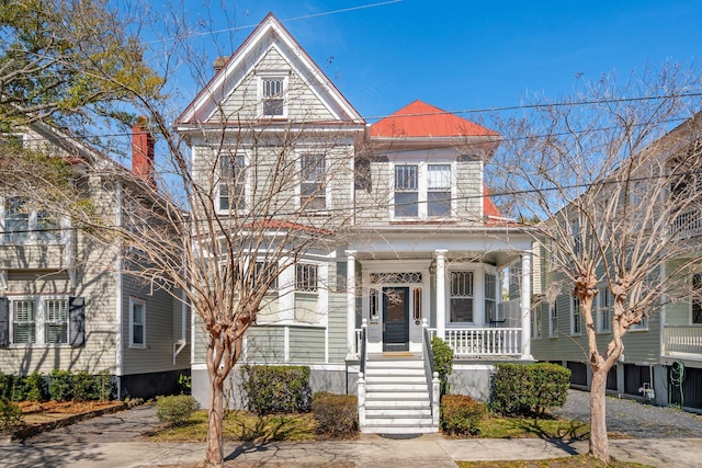 view of front of house featuring covered porch and a chimney