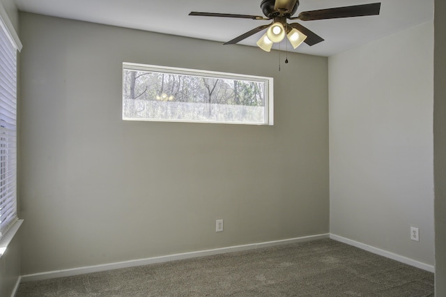 carpeted empty room featuring baseboards and a ceiling fan