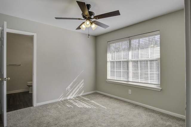 unfurnished room with carpet flooring, a ceiling fan, and baseboards