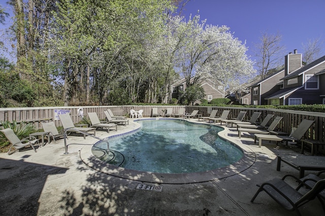 pool featuring a residential view, a patio, and fence