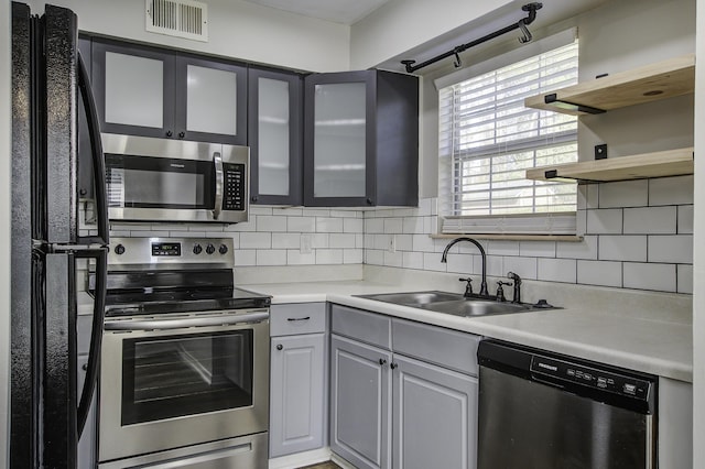 kitchen with tasteful backsplash, visible vents, appliances with stainless steel finishes, and a sink