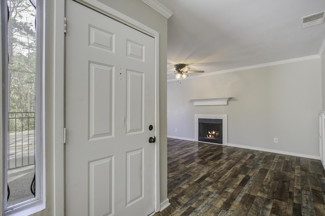 unfurnished living room with visible vents, a lit fireplace, dark wood-style floors, and ornamental molding