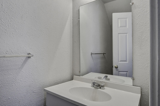 bathroom with vanity and a textured wall