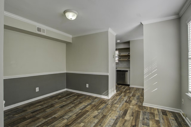 empty room with dark wood finished floors, crown molding, visible vents, and baseboards