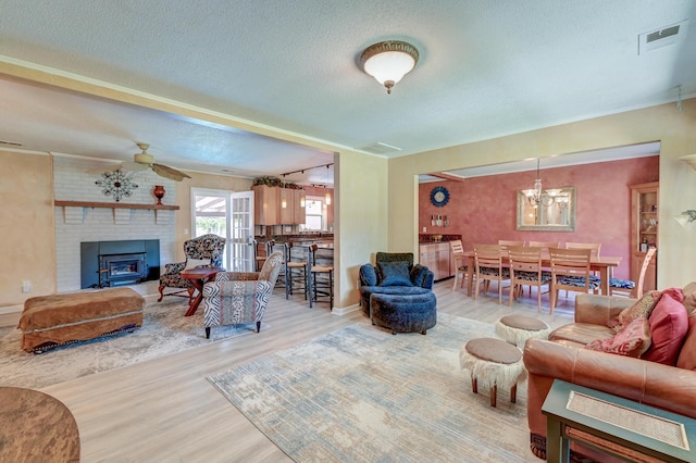 2506 Birkenhead Dr, Charleston, SC 29414 - living room with a brick fireplace, wood finished floors, and a textured ceiling