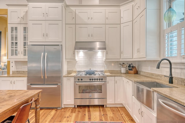 312 Hobcaw Dr, Mount Pleasant, SC 29464 - kitchen featuring appliances with stainless steel finishes, extractor fan, white cabinetry, and tasteful backsplash