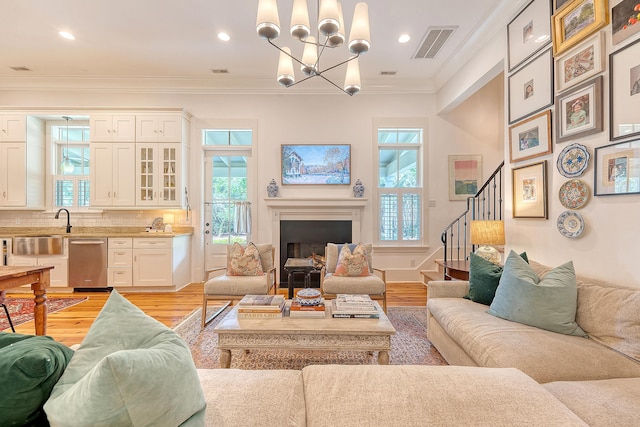312 Hobcaw Dr, Mount Pleasant, SC 29464 - living area featuring crown molding, plenty of natural light, stairs, light wood finished floors, and a chandelier