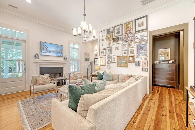 312 Hobcaw Dr, Mount Pleasant, SC 29464 - living area with ornamental molding, stairway, light wood-style flooring, a chandelier, and a fireplace