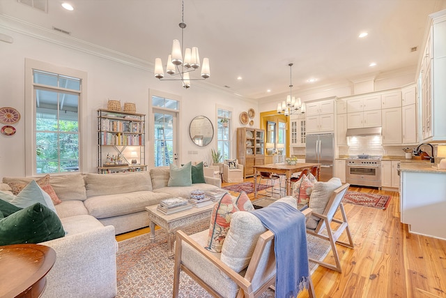 312 Hobcaw Dr, Mount Pleasant, SC 29464 - living room featuring a chandelier, light wood-style floors, crown molding, and recessed lighting